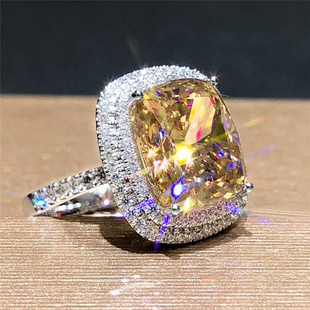 Anillo de cóctel llamativo con halo de cojín