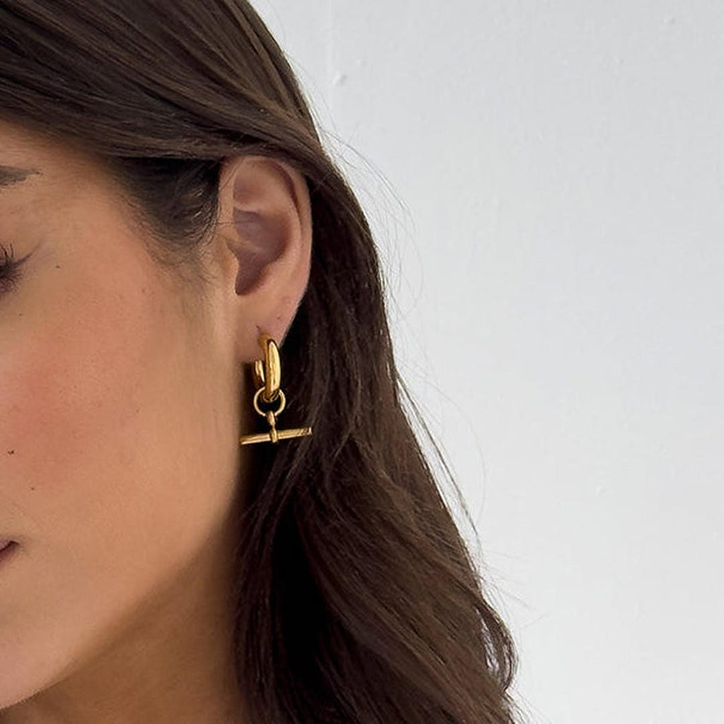 Aros dorados elegantes con barra en T