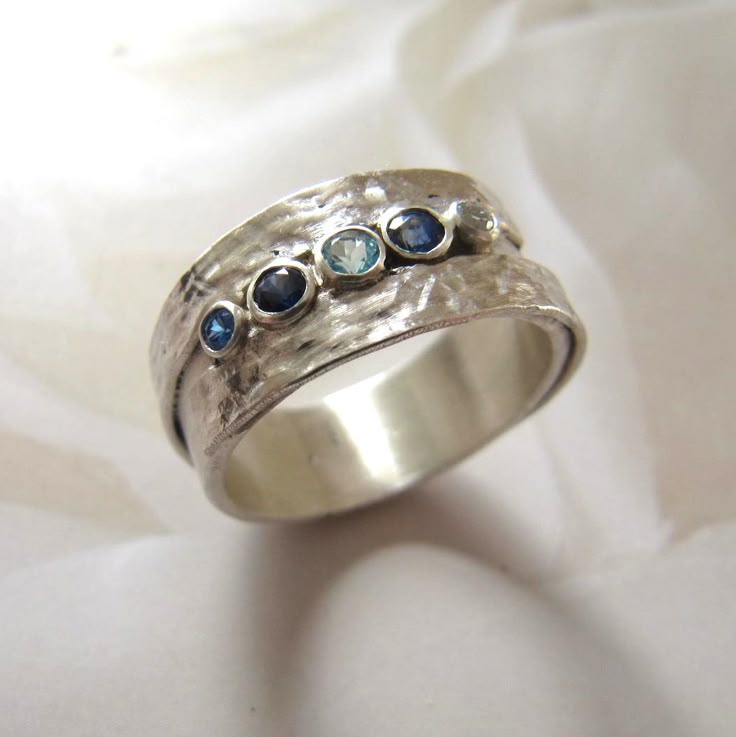 Anillo plateado con piedras incrustadas azules