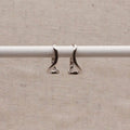 Aretes de aro plateados con ondas abstractas
