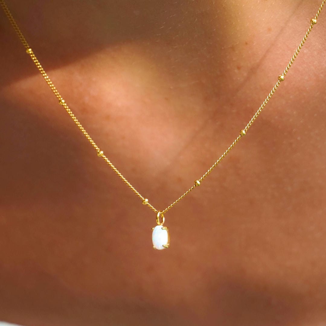 Gold Beaded Necklace with Opal Pendant worn by a model