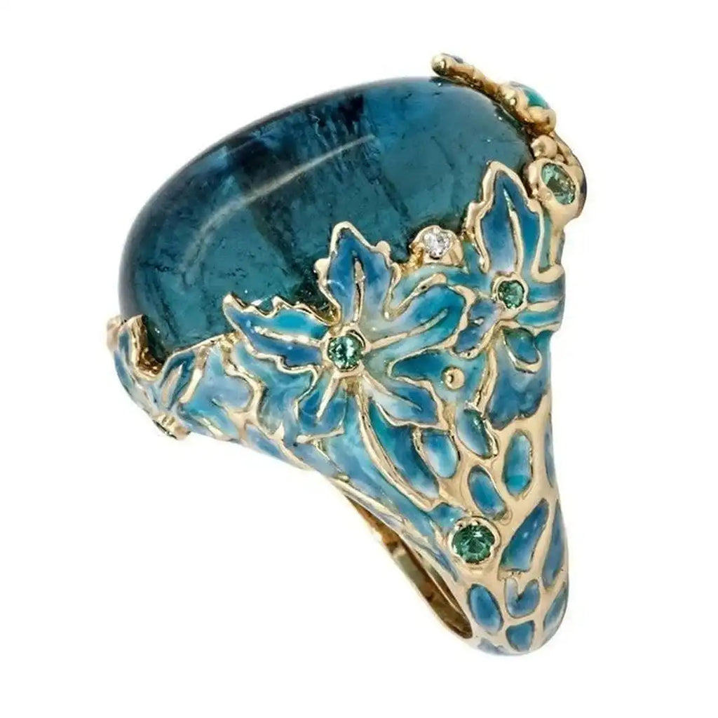 Elegante anillo de flor dorada con piedra azul