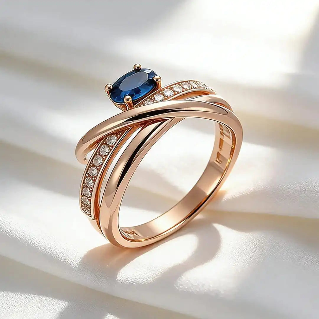 Anillo vintage de oro rosa con circonitas cúbicas azules y forma de cruz