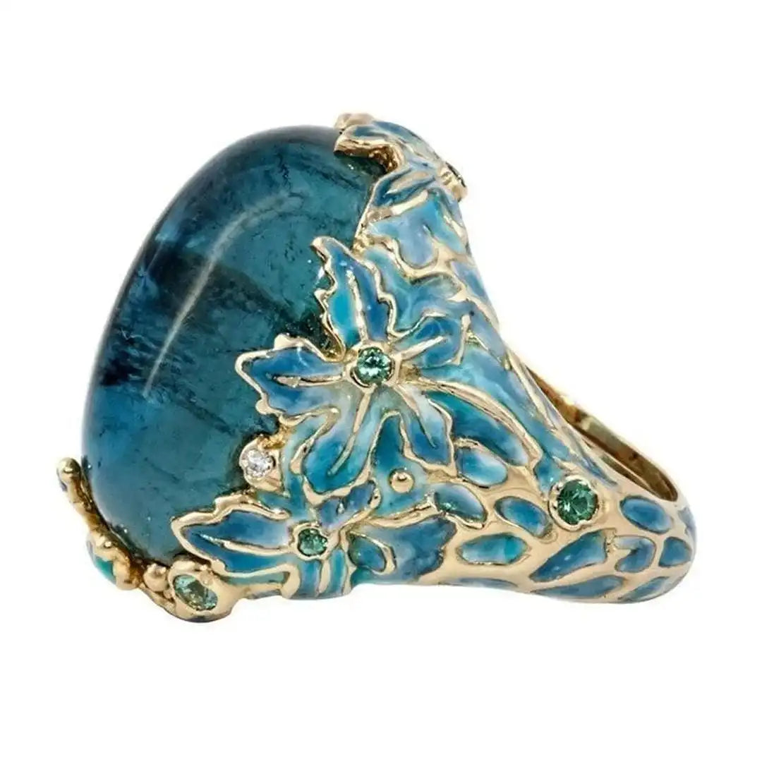 Elegante anillo de flor dorada con piedra azul