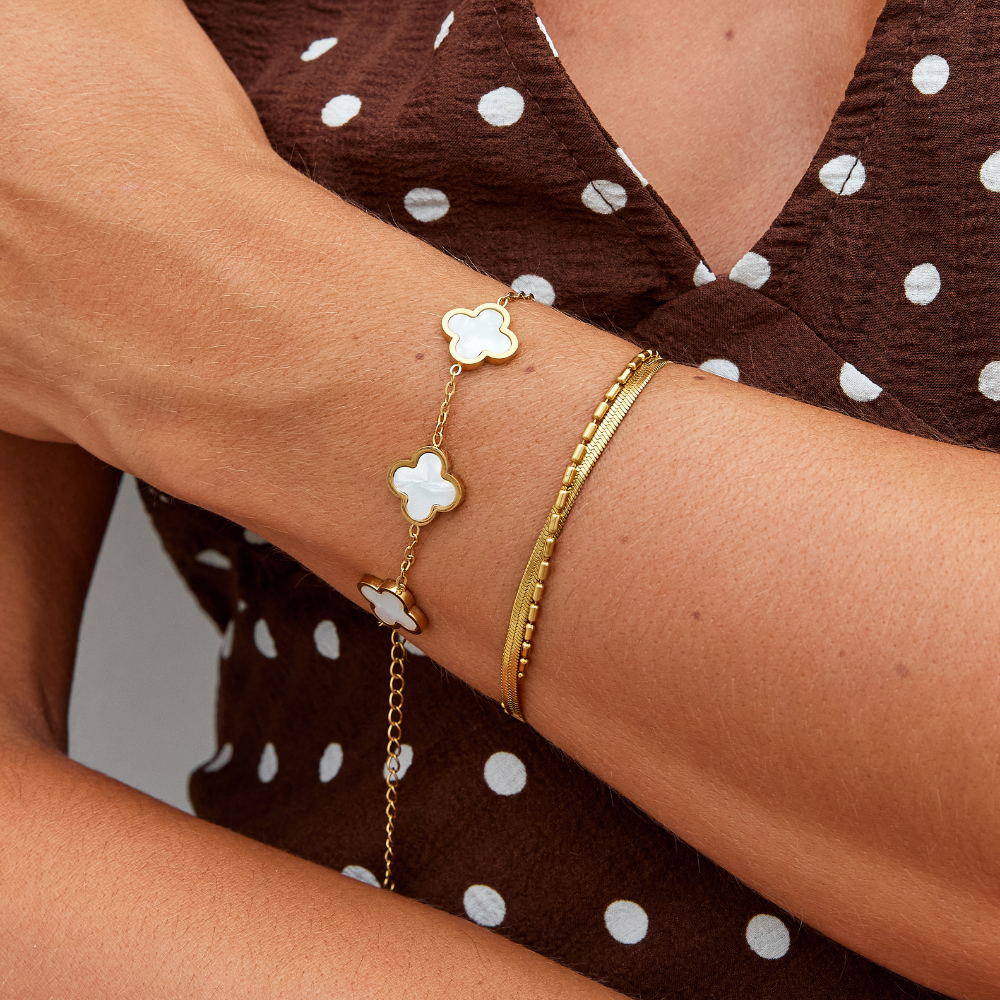 Pulsera de trébol blanco puesta en la muñeca