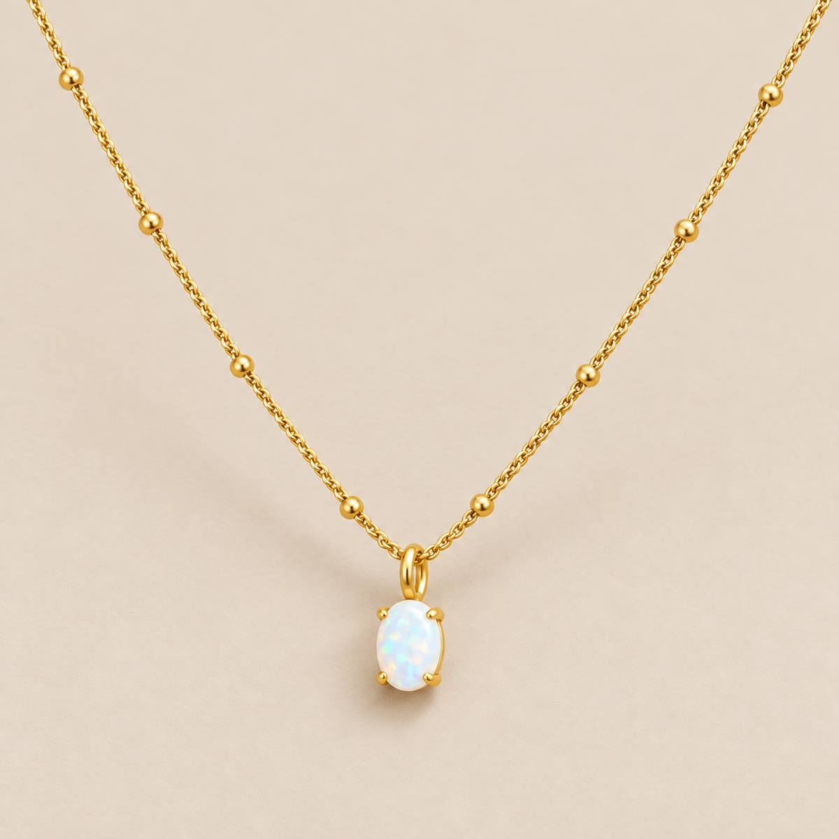 Gold Beaded Necklace with Opal Pendant — cream studio photograph