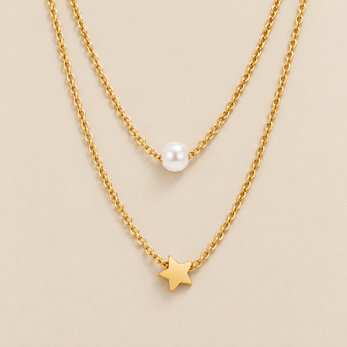Collar de perlas y estrella dorada en capas sobre fondo crema