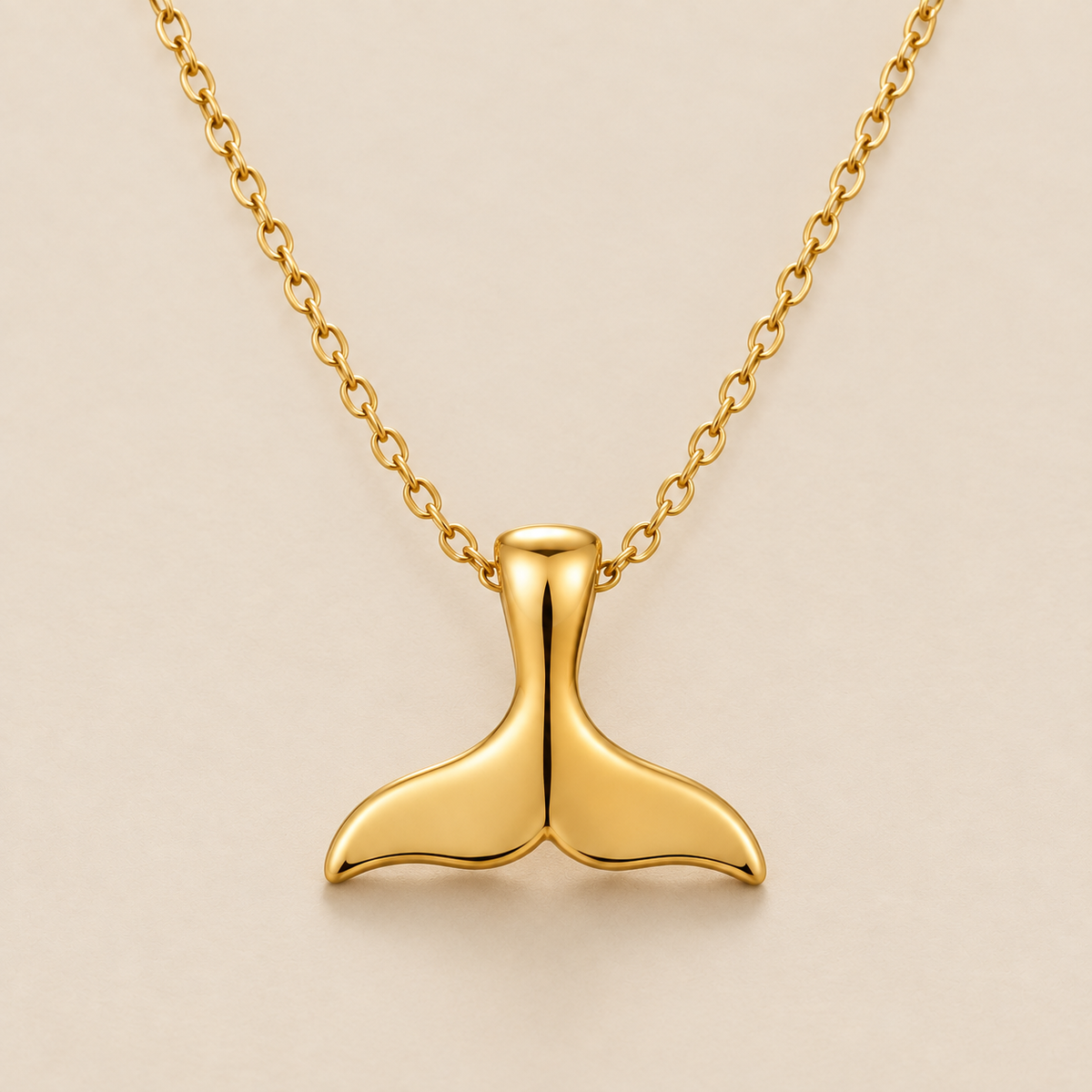 Elegant Whale Tail Necklace — cream studio photograph