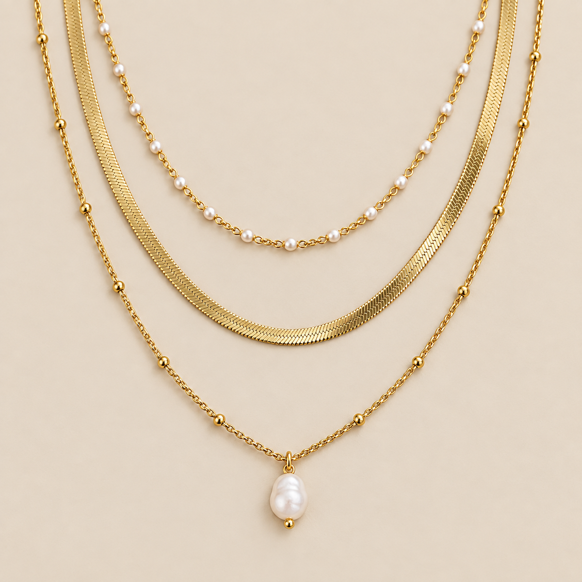 Juego de collar de tres piezas Luminous Tides sobre fondo crema