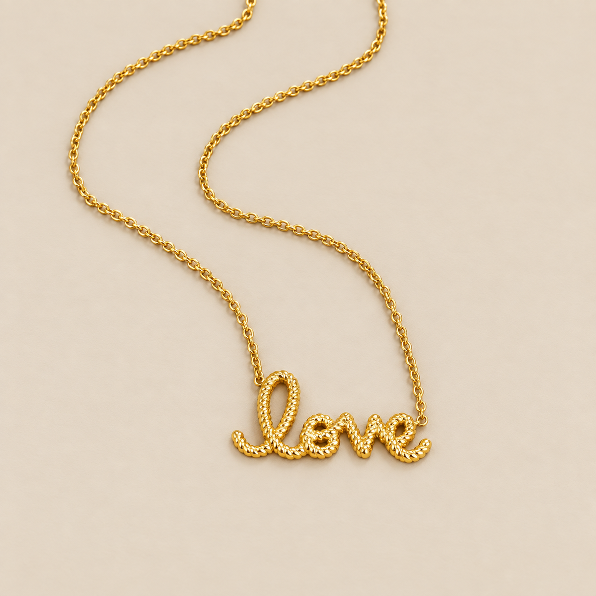 Collar con dije "Love" sobre fondo crema