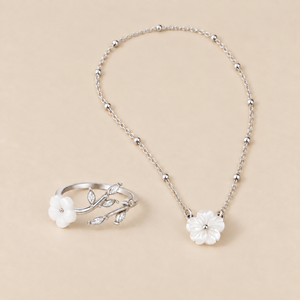 Conjunto de flor blanca plateada sobre fondo crema
