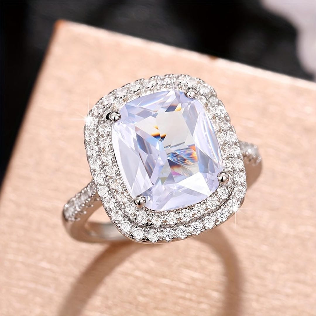 Anillo de cóctel llamativo con halo de cojín
