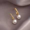 Elegantes aretes de perlas doradas brillantes