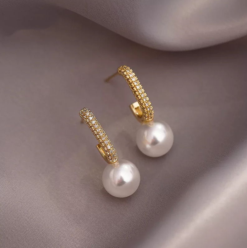 Elegantes aretes de perlas doradas brillantes