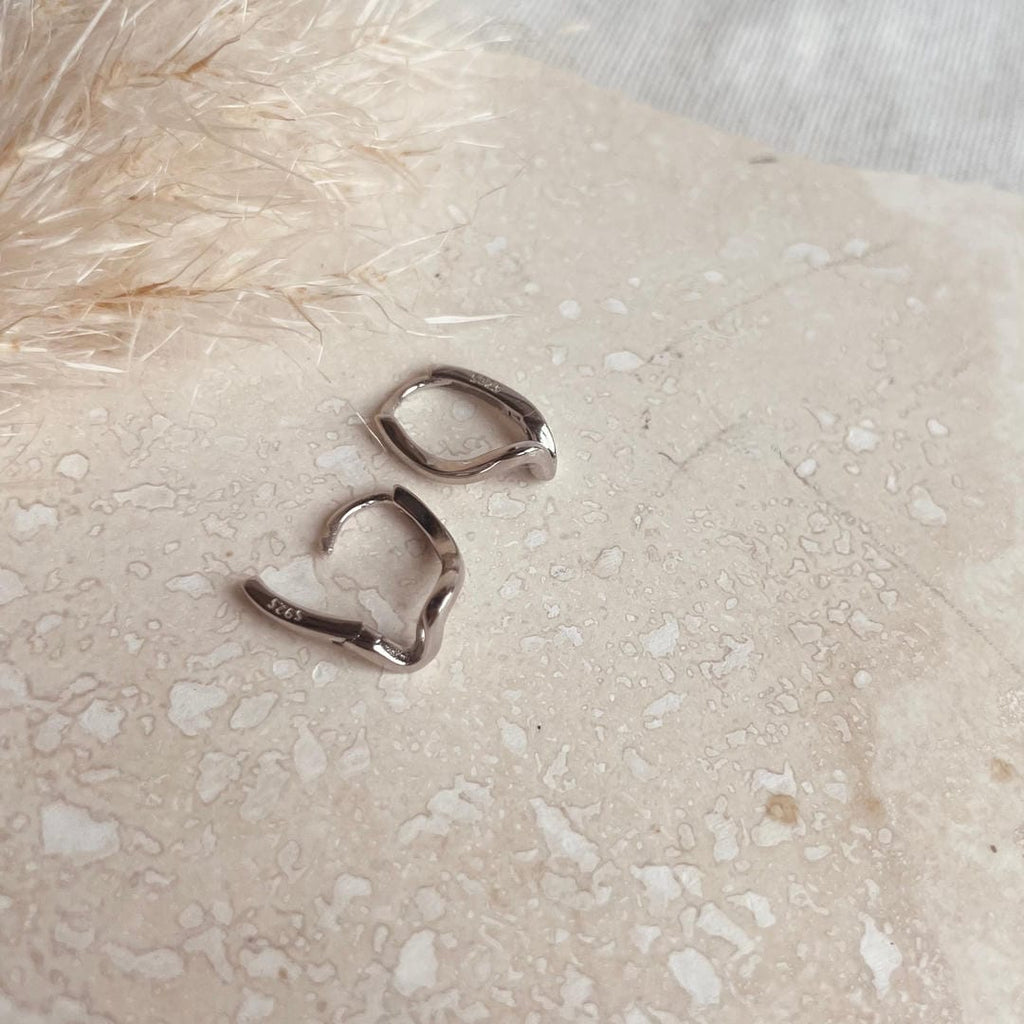 Aretes de aro plateados con ondas abstractas