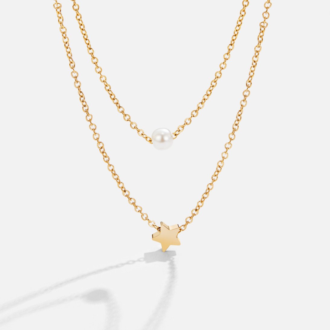 Collar de perlas y estrella dorada en capas