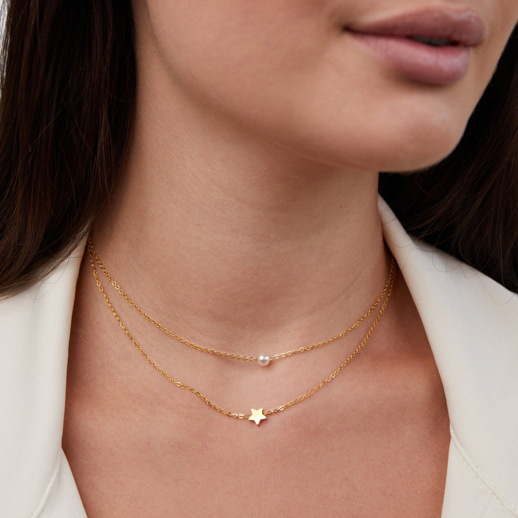 Collar de perlas y estrella dorada en capas