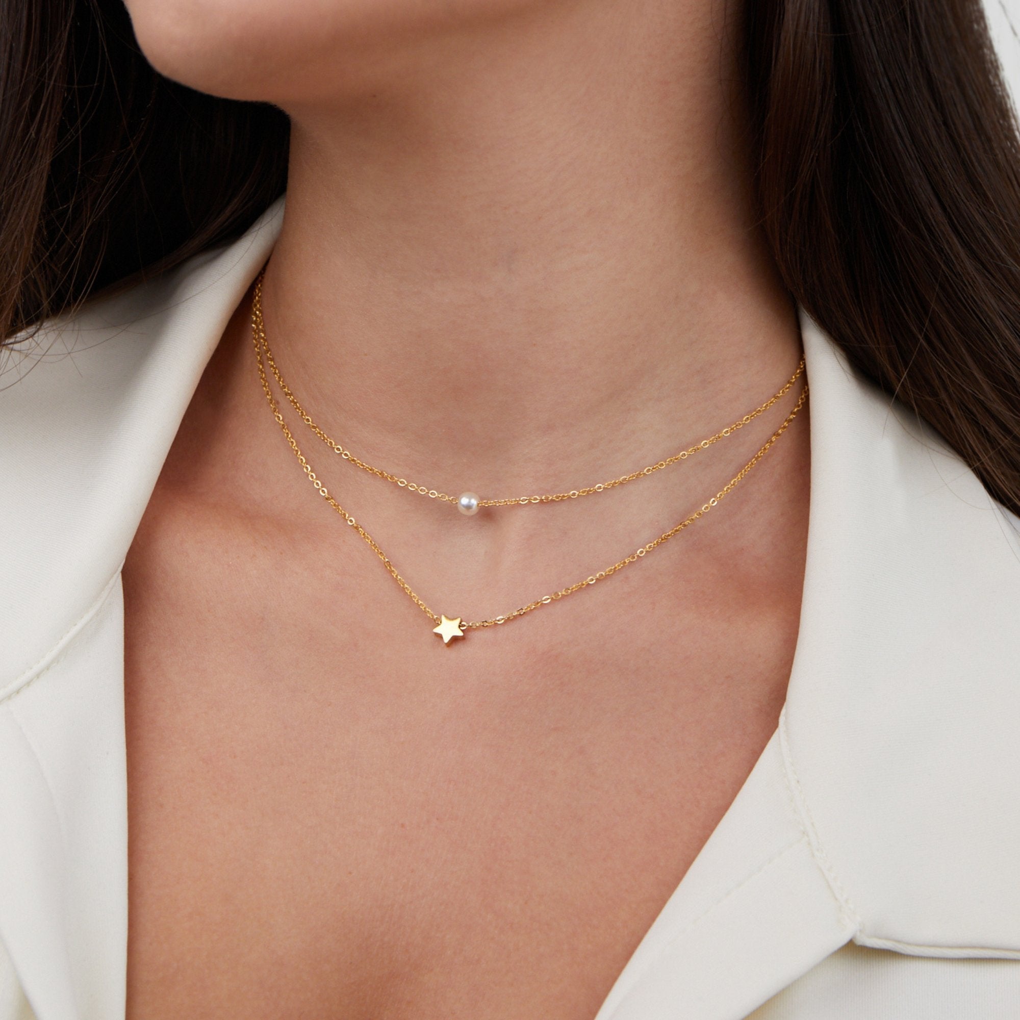 Collar de perlas y estrella dorada en capas