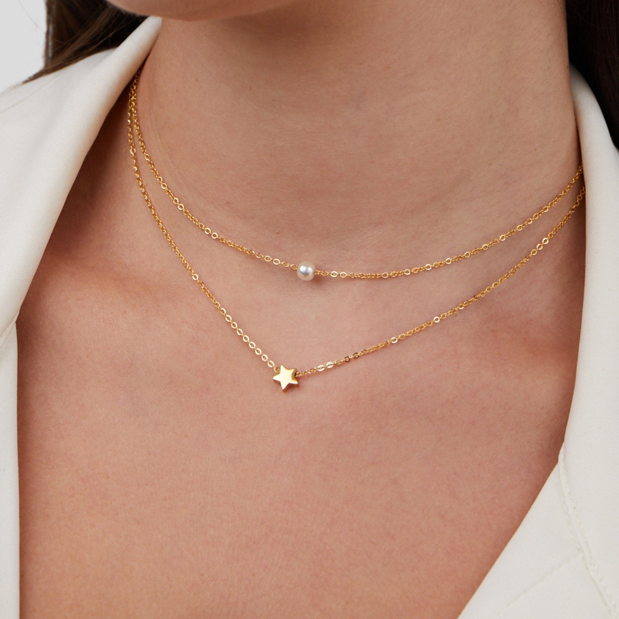 Collar de perlas y estrella dorada en capas