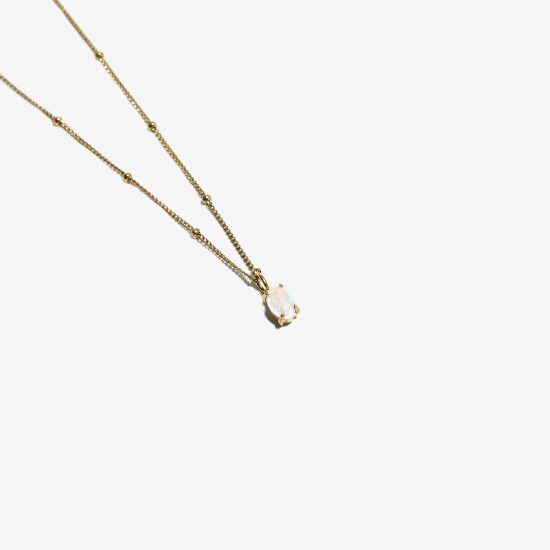 Collar de cuentas doradas con colgante de ópalo