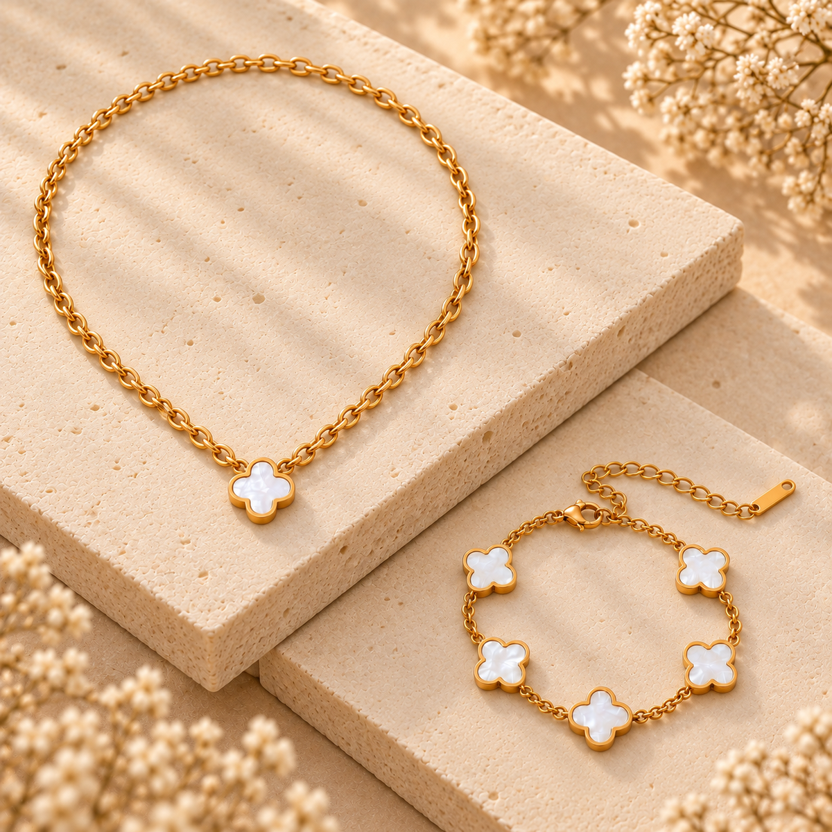 Conjunto de collar y pulsera de trébol blanco sobre piedra crema