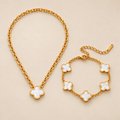 Conjunto de collar y pulsera de trébol blanco sobre fondo crema